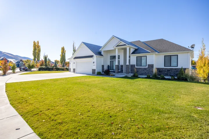 Craftsman inspired home with stone siding, driveway, a front yard, an attached garage, and roof with shingles
