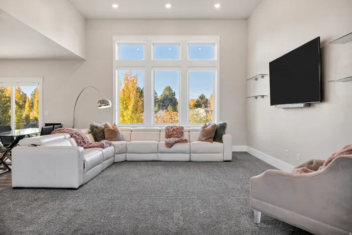 Carpeted living area featuring a high ceiling and recessed lighting