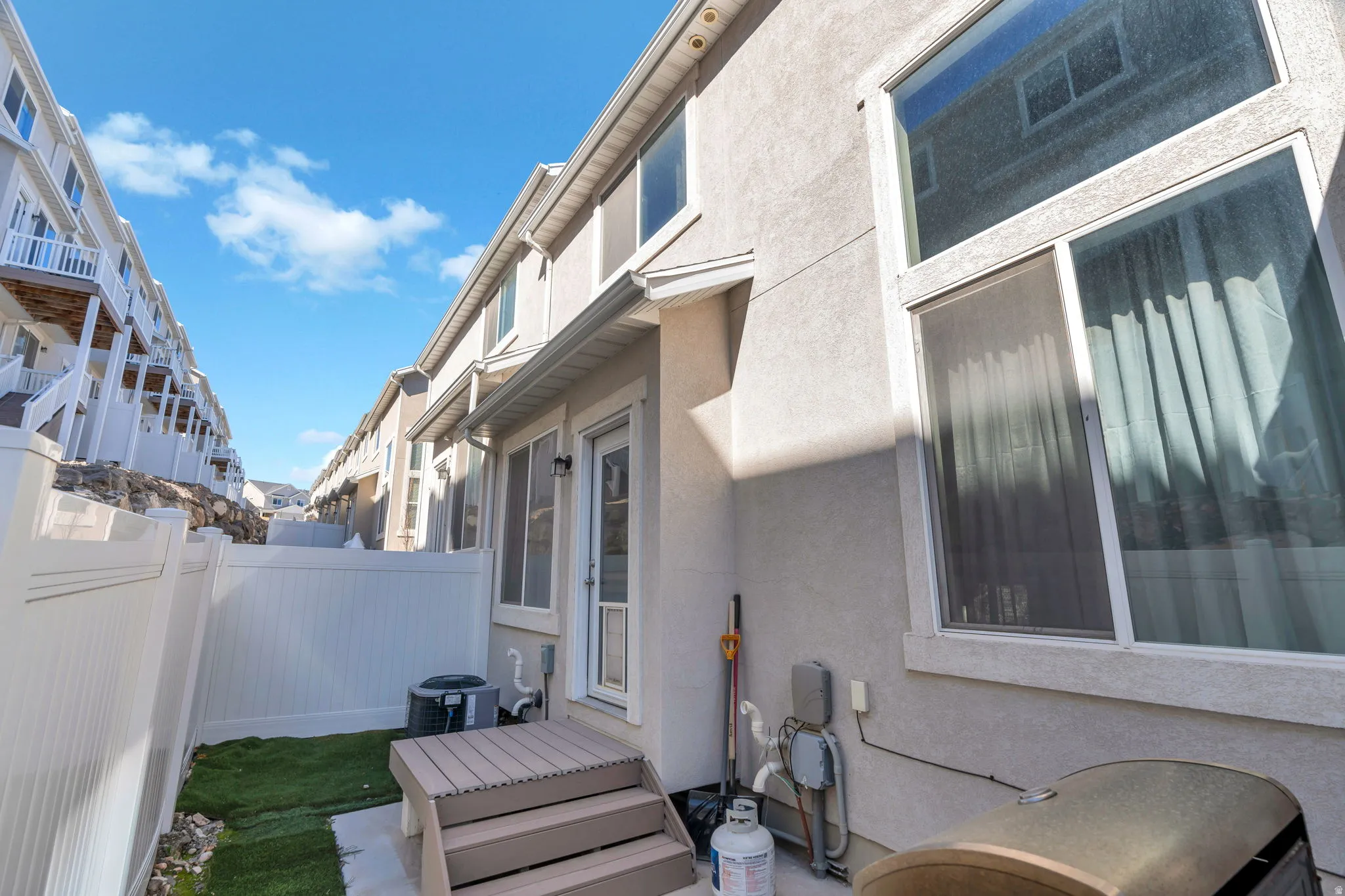 View of side of home with stucco siding and a patio area