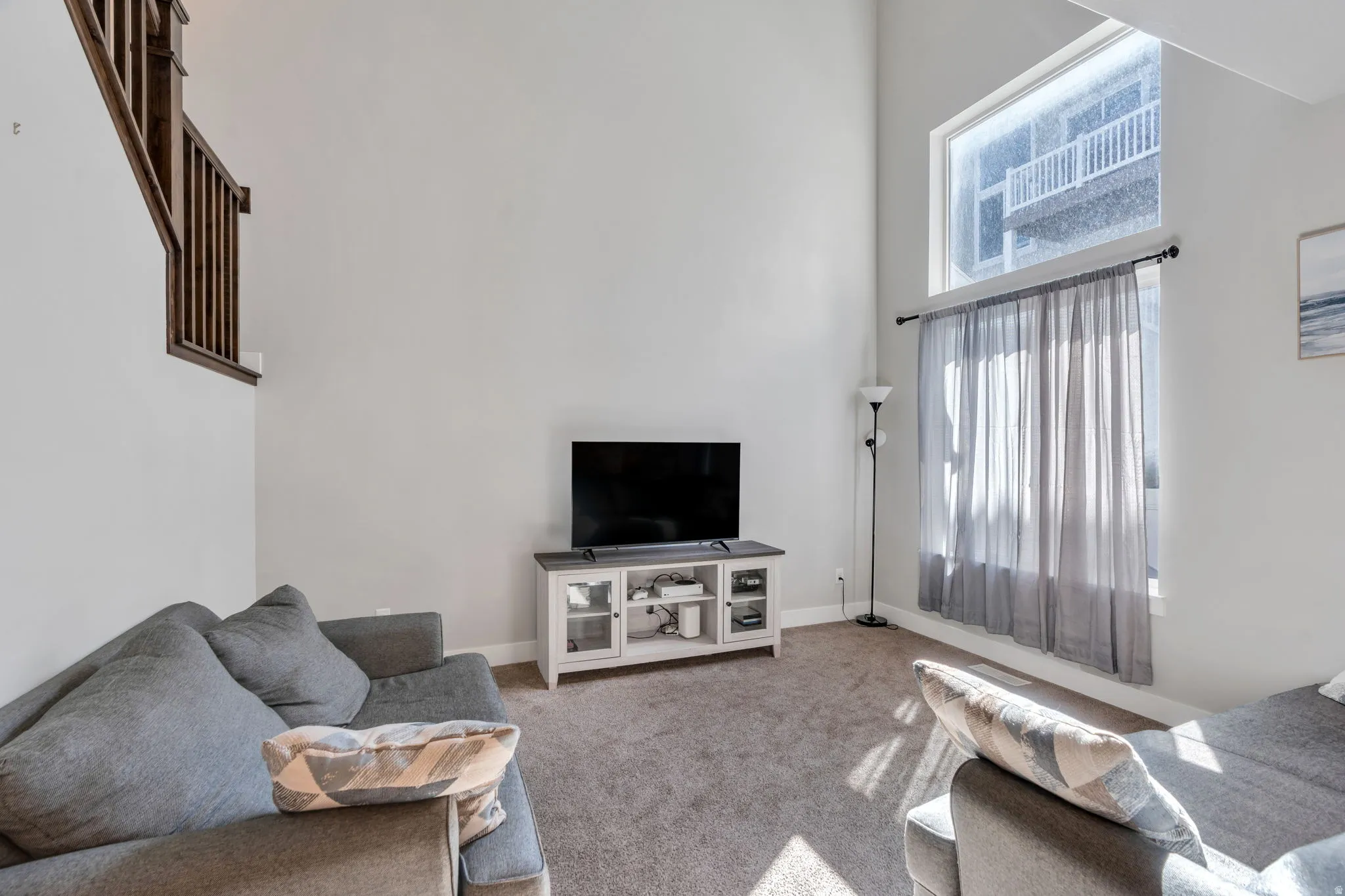Living room with a high ceiling and carpet flooring