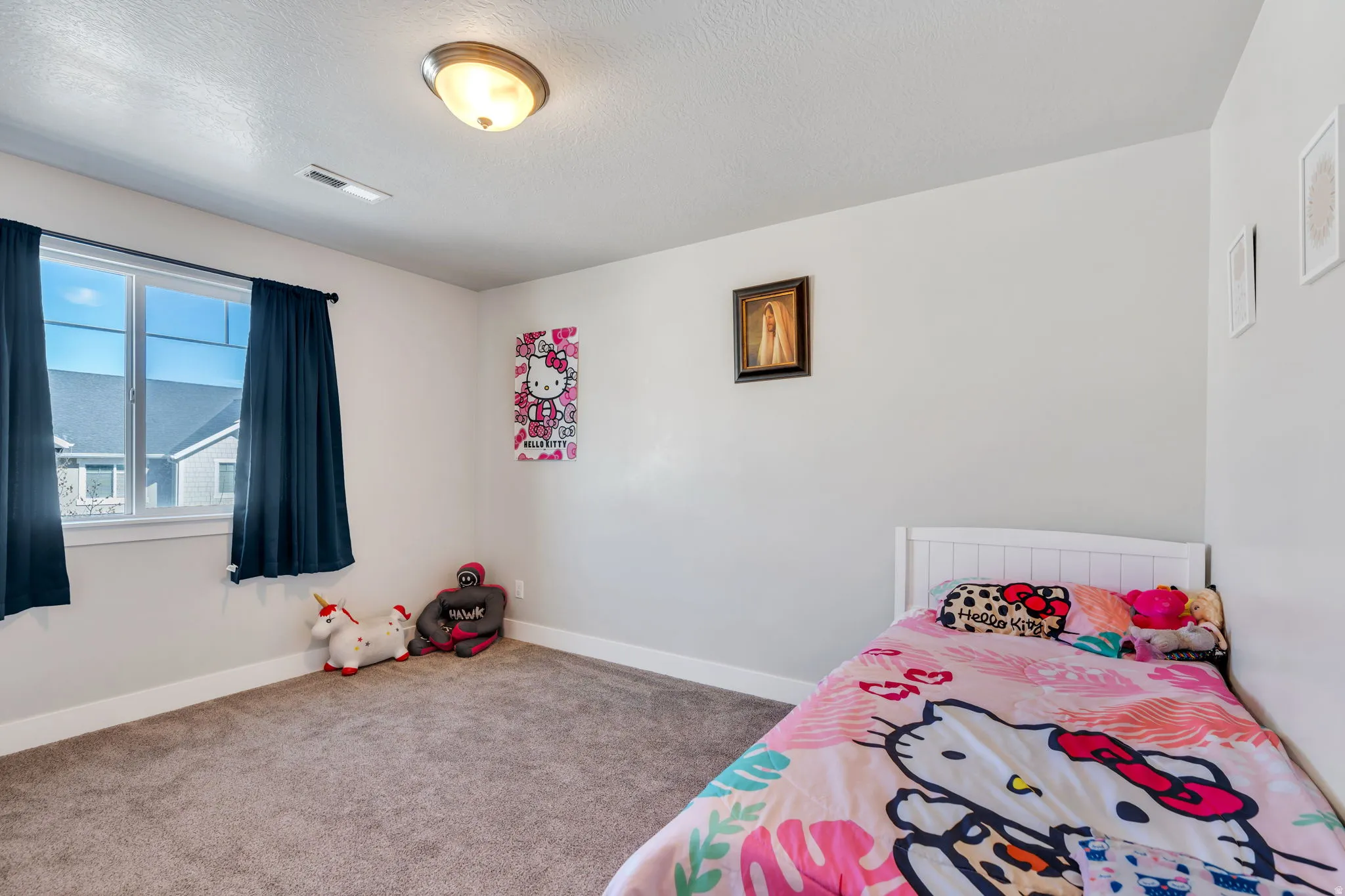 Carpeted bedroom with baseboards and a textured ceiling