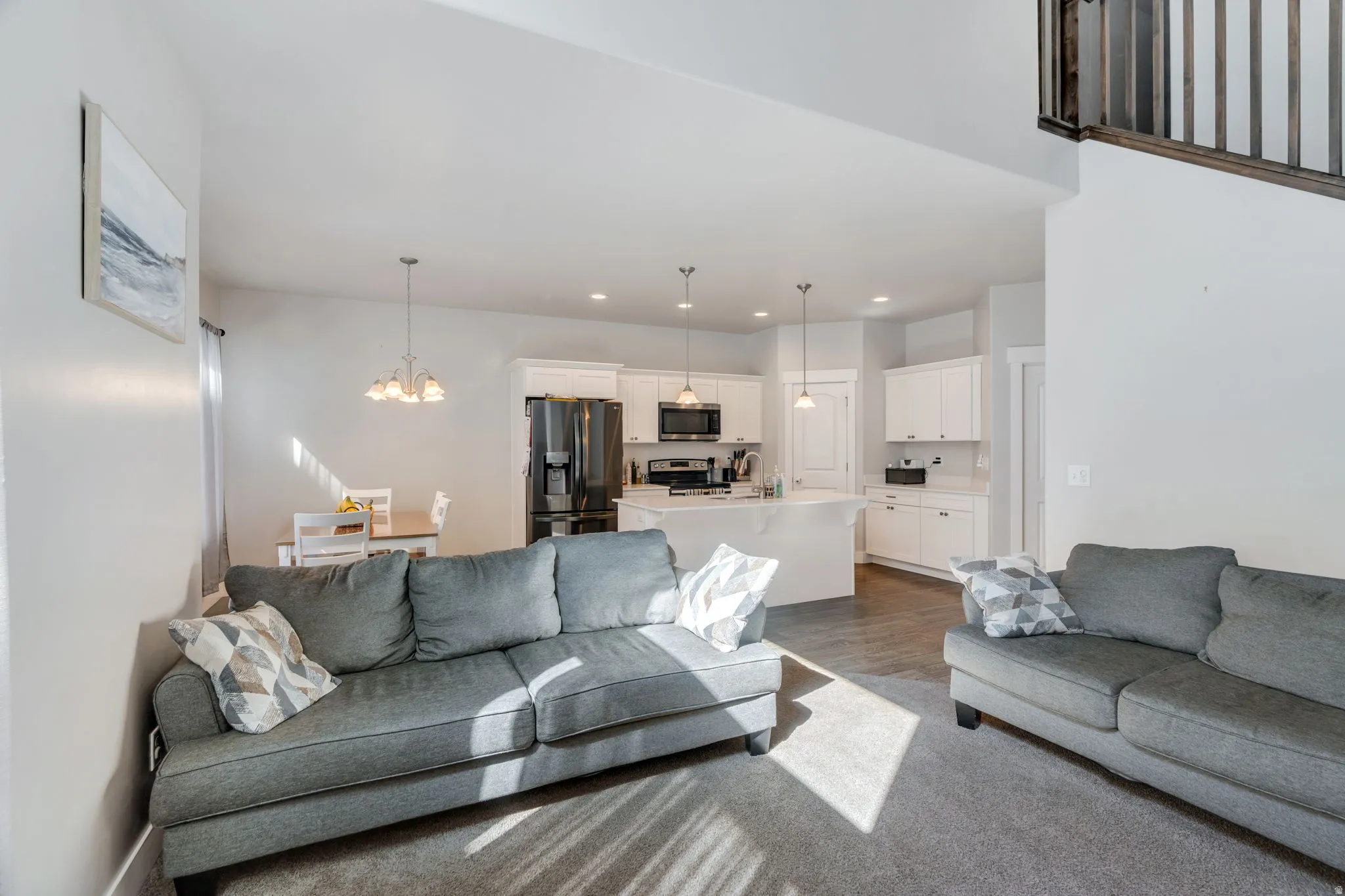 Living room featuring suspended lighting and wood finished floors