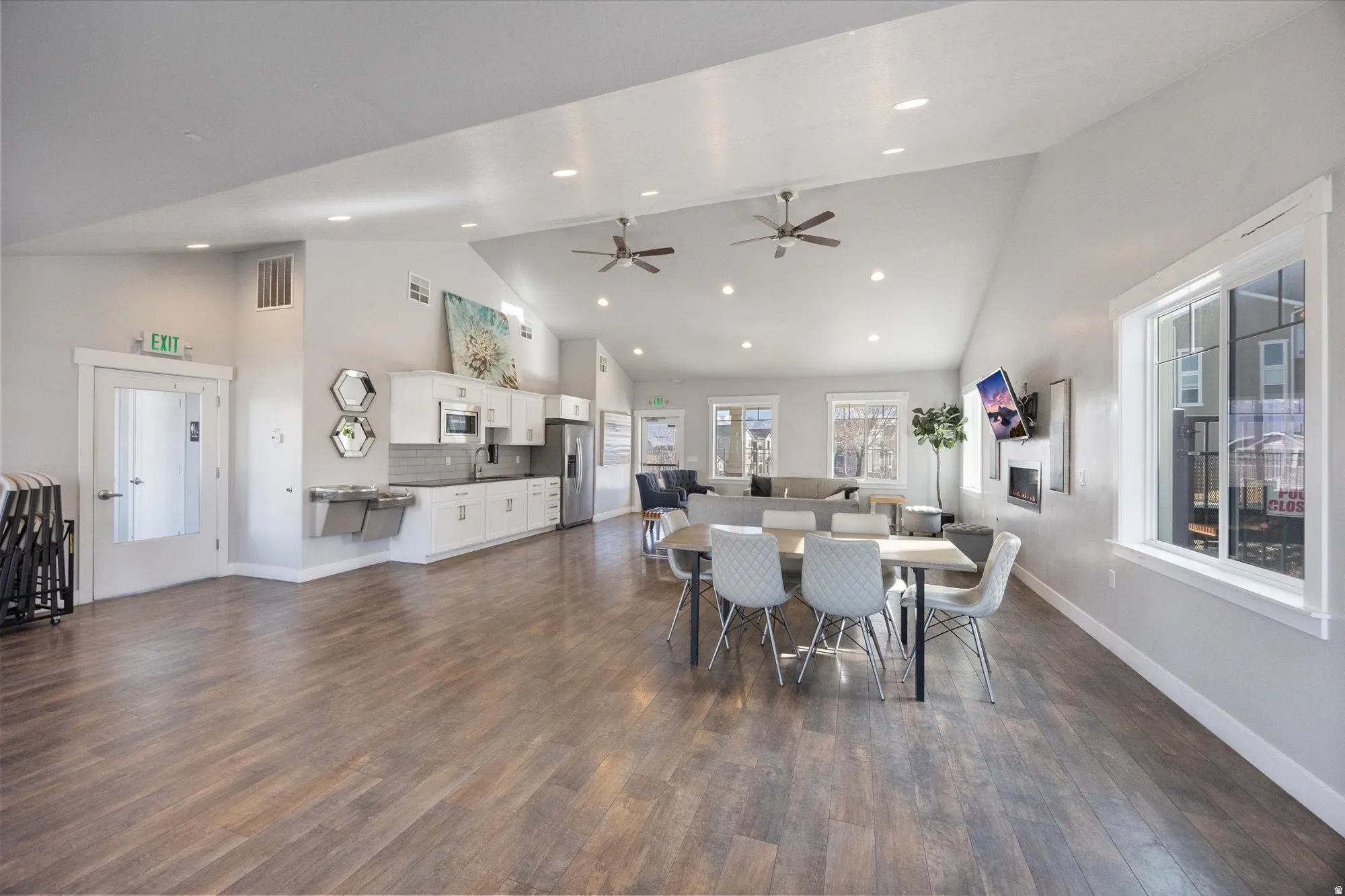 Dining space with dark wood finished floors, ceiling fan, vaulted ceiling, and recessed lighting