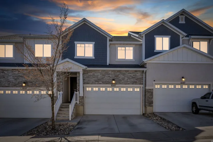 Craftsman-style house featuring board and batten siding, concrete driveway, stone siding, and an attached garage
