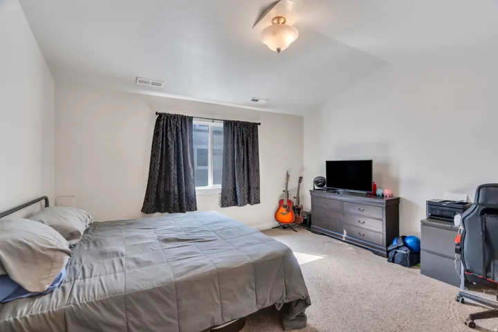 Bedroom featuring lofted ceiling and carpet floors