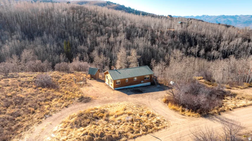 View of subject property with mountains and a forest/ Versatile lot.