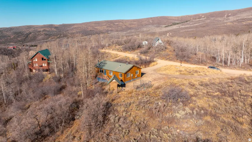 Aerial view of property and surrounding area with a mountainous background