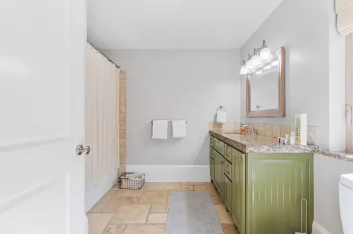 Bathroom featuring stone tile flooring and double vanity