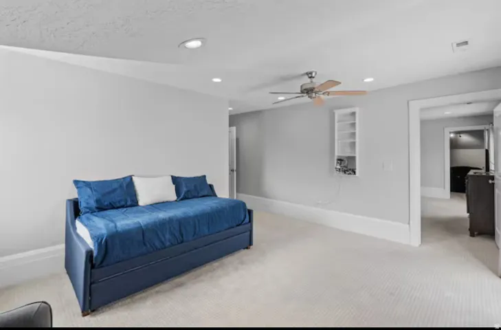 Bedroom with light carpet, recessed lighting, and a ceiling fan