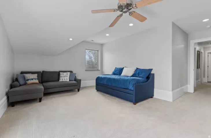 Living area featuring light colored carpet, recessed lighting, vaulted ceiling, and ceiling fan