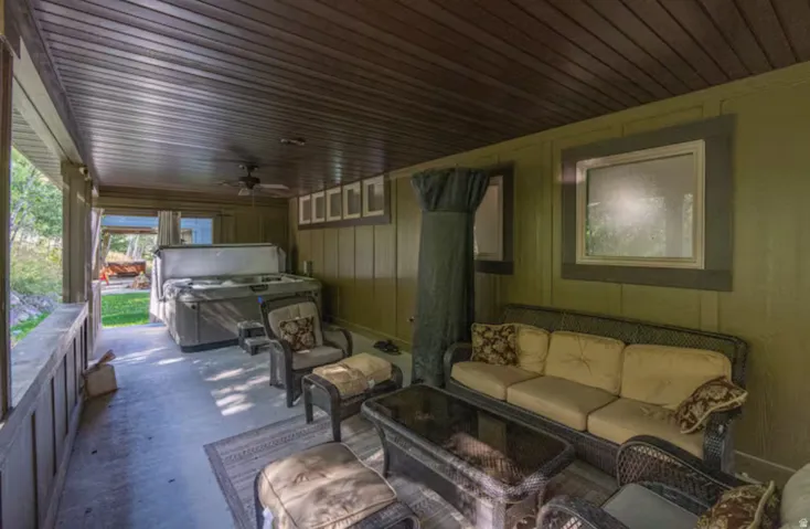 Wooden deck featuring a ceiling fan, a hot tub, an outdoor hangout area, and a patio
