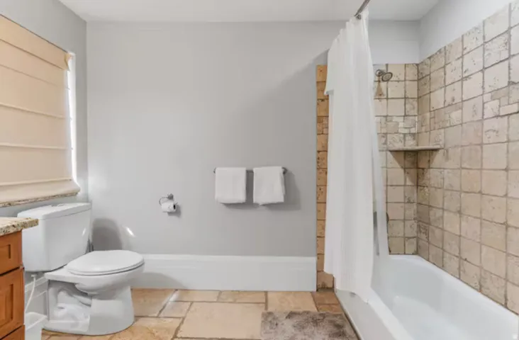 Bathroom featuring vanity, stone tile floors, and shower / tub combo