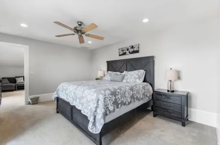 Bedroom with light carpet, ceiling fan, and recessed lighting