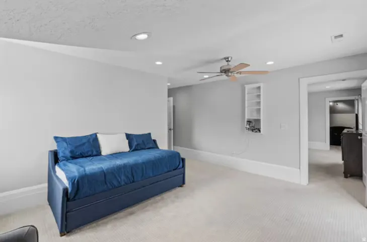 Living area with light colored carpet, recessed lighting, and a ceiling fan