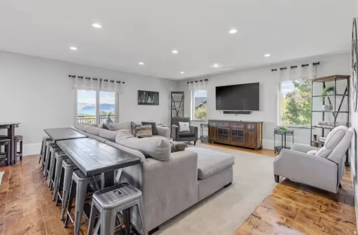 Living area with light wood finished floors, plenty of natural light, and recessed lighting