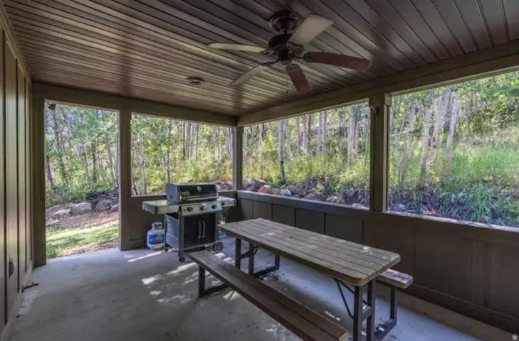 Sunroom with ceiling fan and a patio