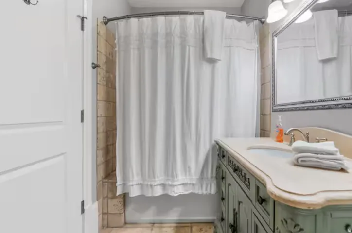 Full bathroom with shower / tub combo with curtain and vanity