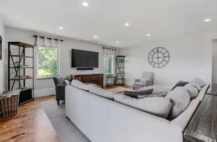 Living area with light wood finished floors and recessed lighting