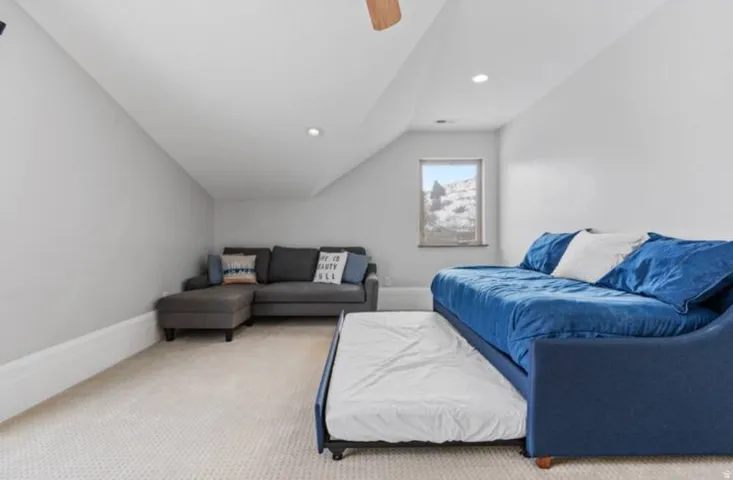Carpeted living room featuring lofted ceiling, ceiling fan, and recessed lighting