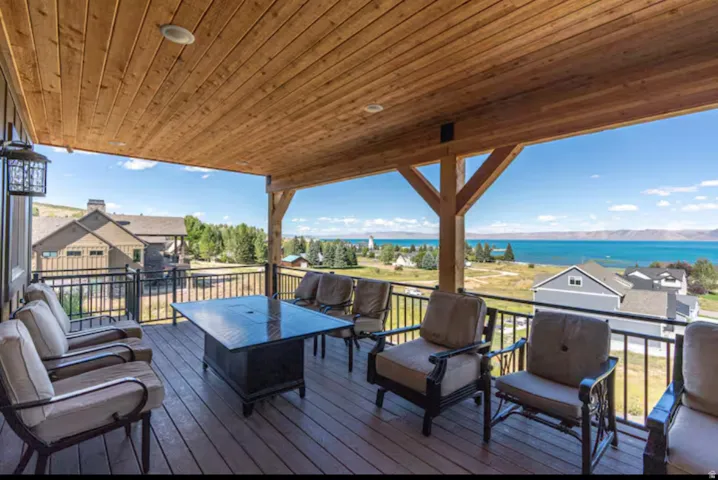 Wooden deck with an outdoor lounge area and a water view