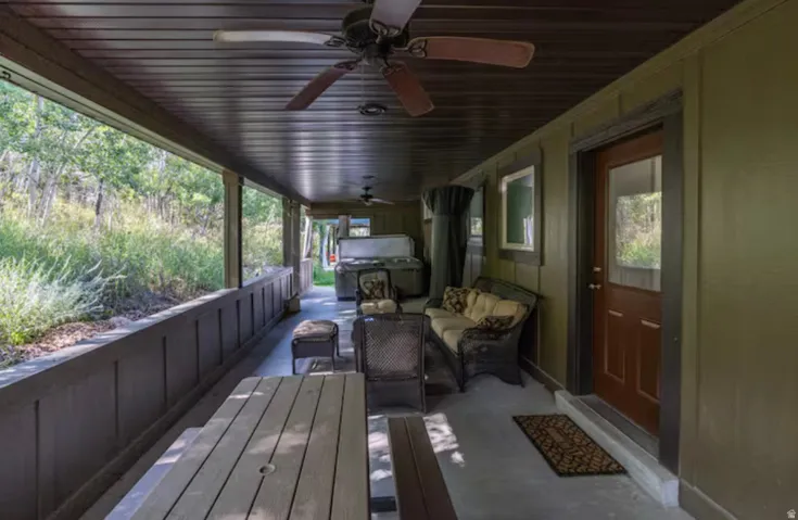 Wooden deck featuring an outdoor lounge area and a ceiling fan