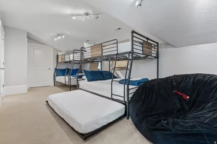 Bedroom with vaulted ceiling and light carpet