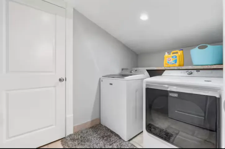 Laundry area featuring washer and dryer and lofted ceiling