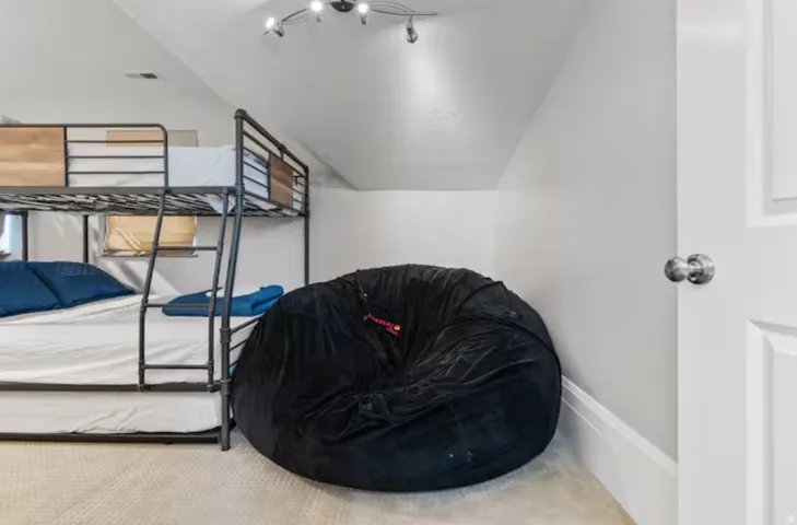 Carpeted bedroom with lofted ceiling