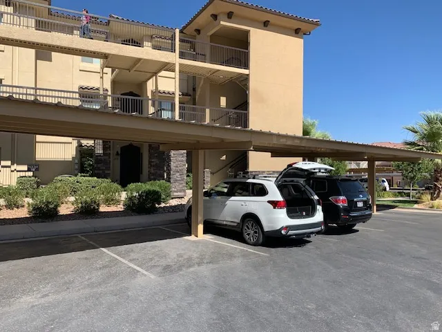View of apartment building / complex featuring covered parking