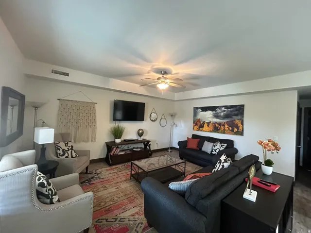 Living room featuring a ceiling fan and baseboards