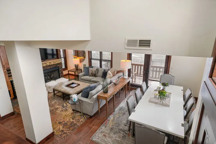 Living area featuring dark wood-style flooring, a fireplace, and a high ceiling