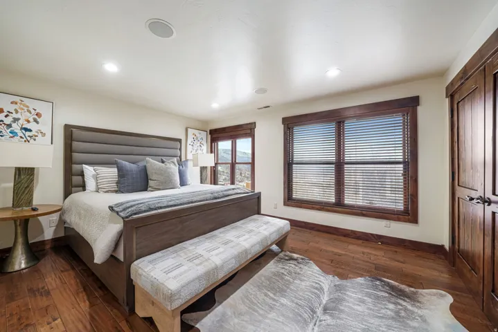 Bedroom featuring dark wood finished floors, recessed lighting, and a closet
