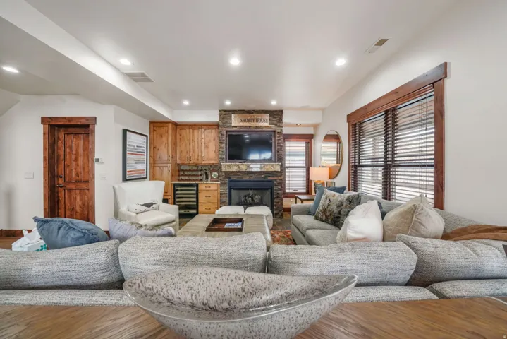 Living room featuring beverage cooler, a fireplace, wood finished floors, and recessed lighting