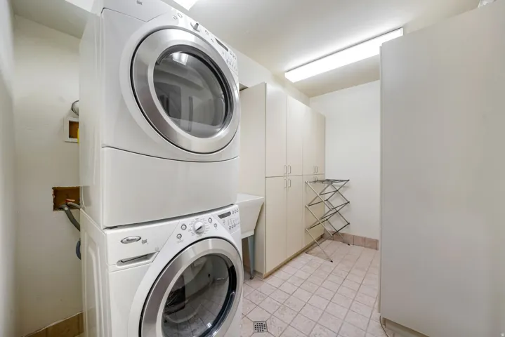 Laundry area with stacked washer / drying machine and cabinet space