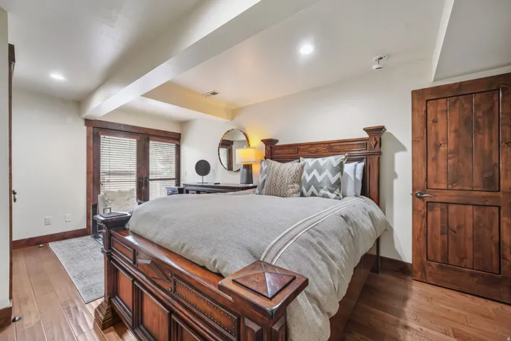 Bedroom featuring light wood-type flooring, french doors, beam ceiling, and recessed lighting