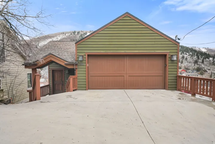 View of front of house featuring a garage, a mountain view, roof with shingles, and concrete driveway