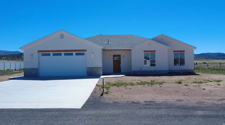 View of front of house featuring a mountain view, a garage, and driveway