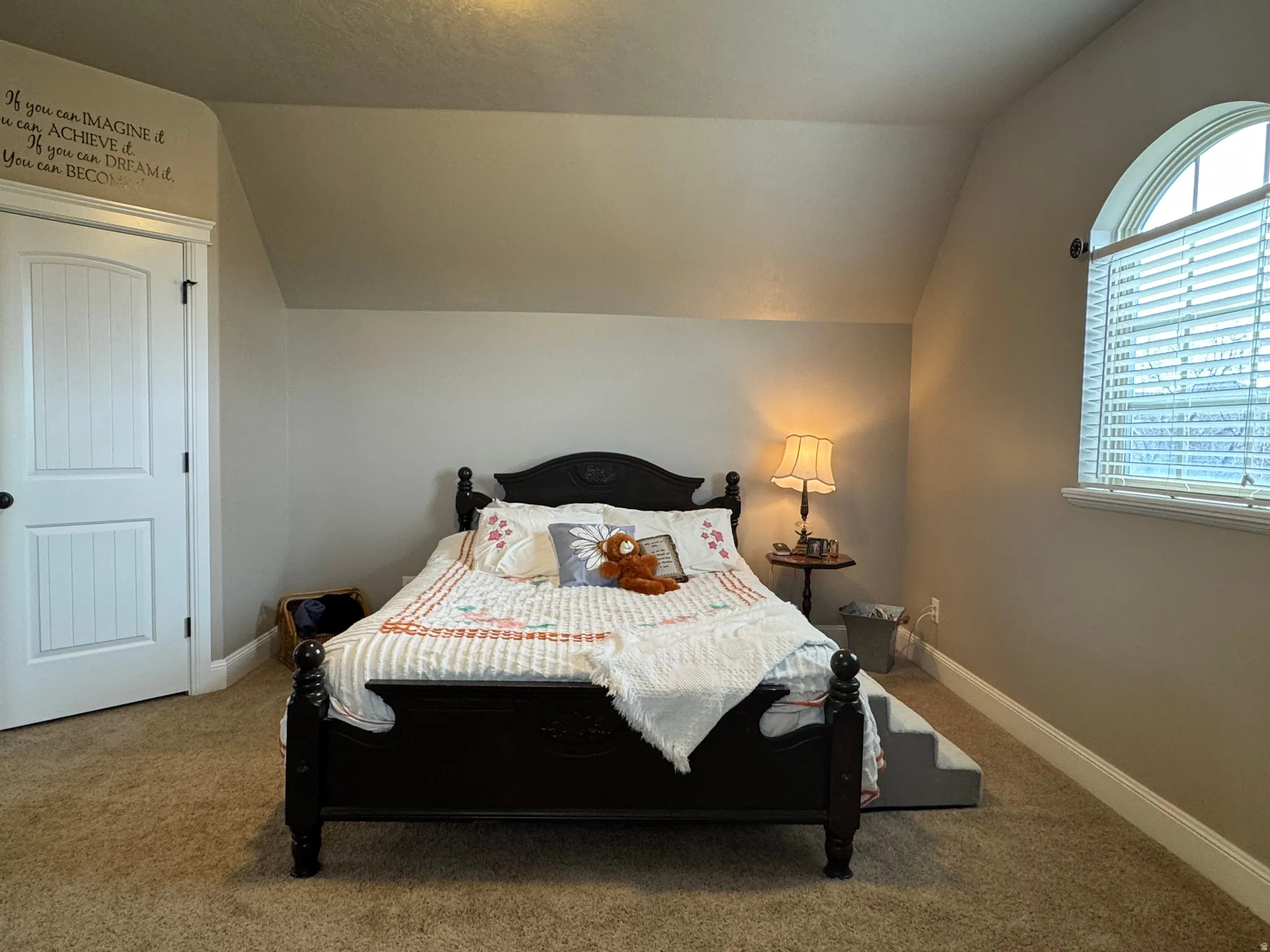 Carpeted bedroom featuring lofted ceiling