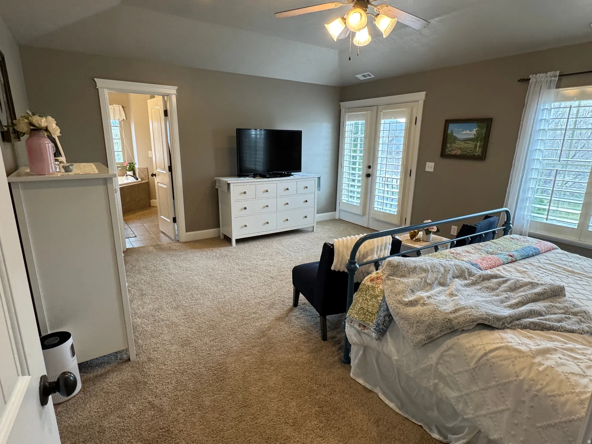 Bedroom with french doors, light colored carpet, multiple windows, access to exterior, and lofted ceiling