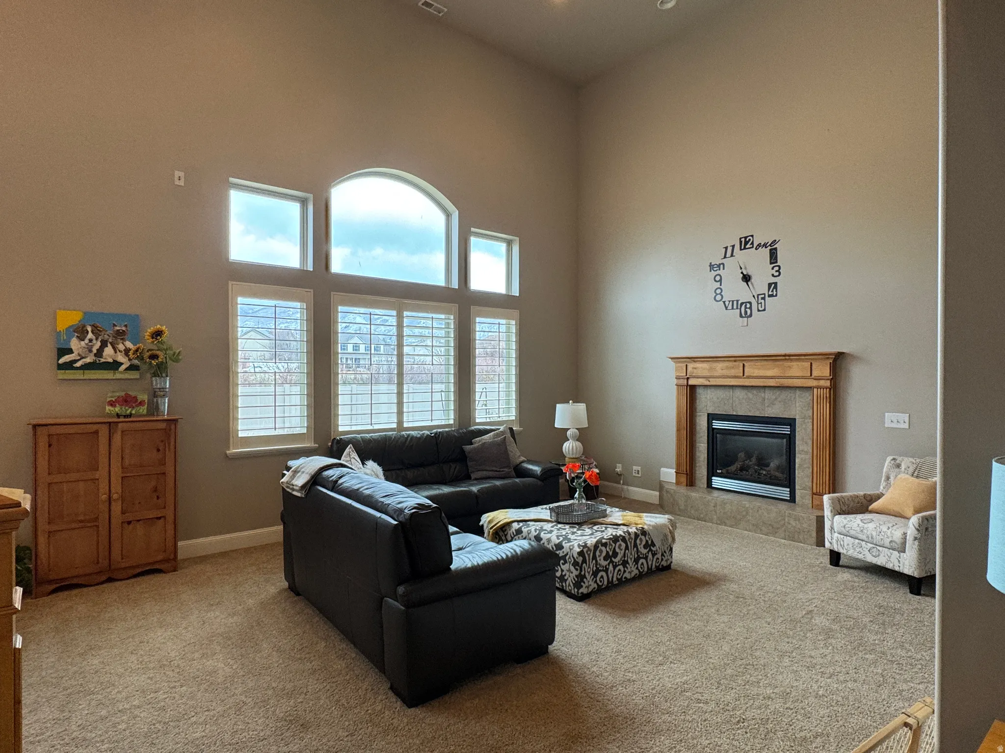 Carpeted living room with a high ceiling and a fireplace