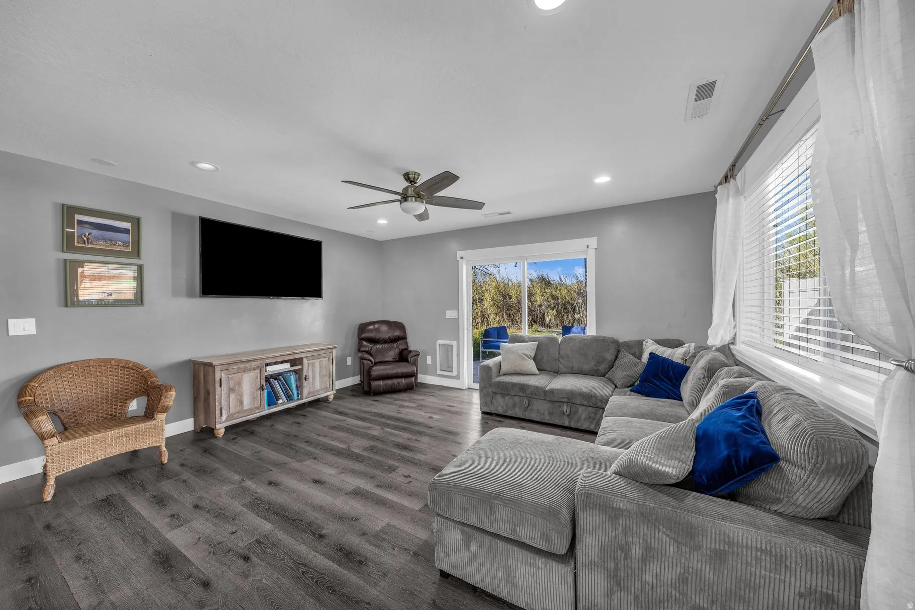 Living room featuring dark wood finished floors, a ceiling fan, and recessed lighting