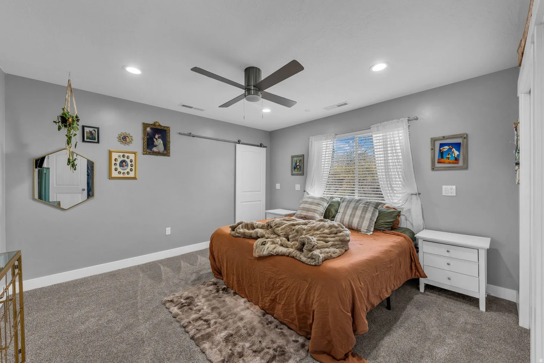 Bedroom with a barn door, carpet floors, recessed lighting, and a ceiling fan