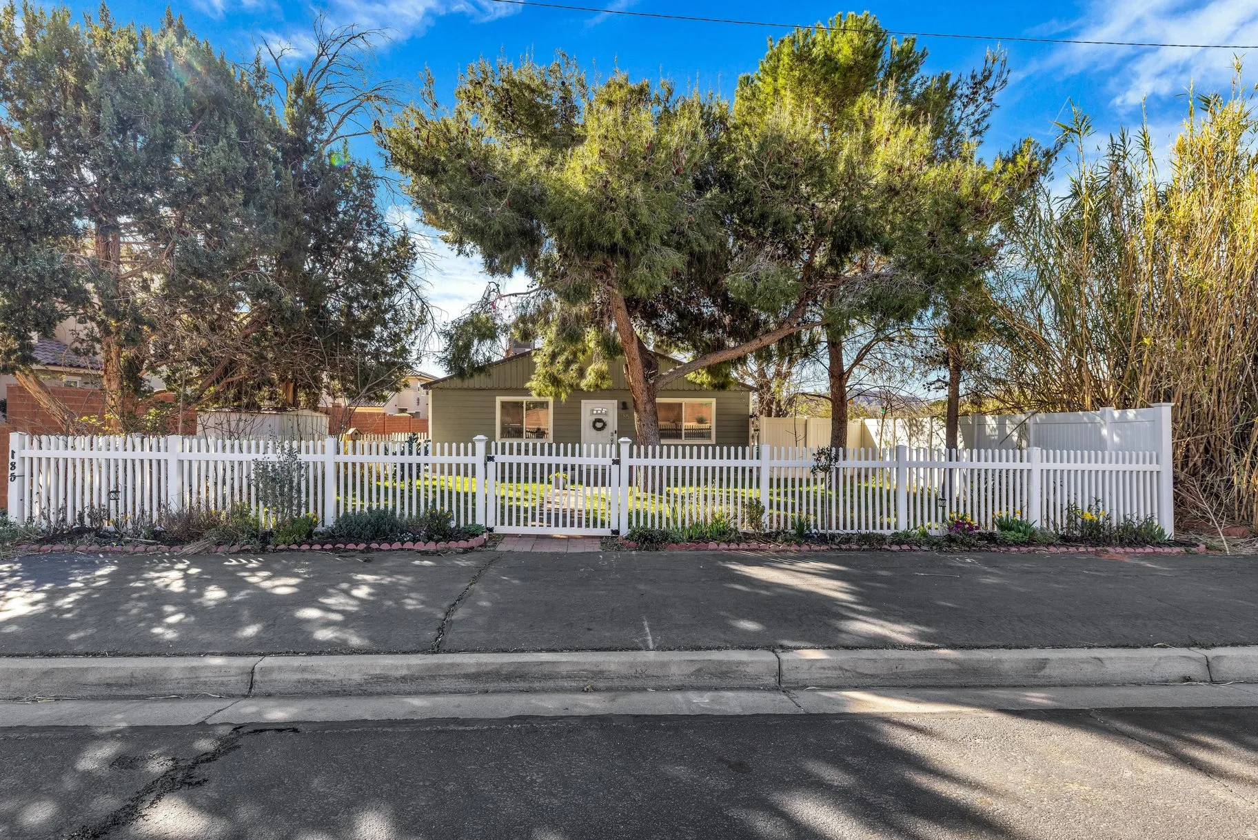 View of property hidden behind natural elements featuring a fenced front yard