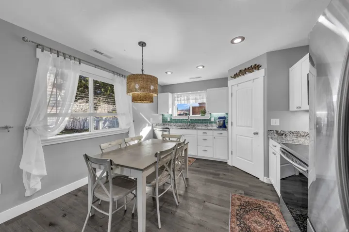 Dining room with dark wood finished floors and recessed lighting
