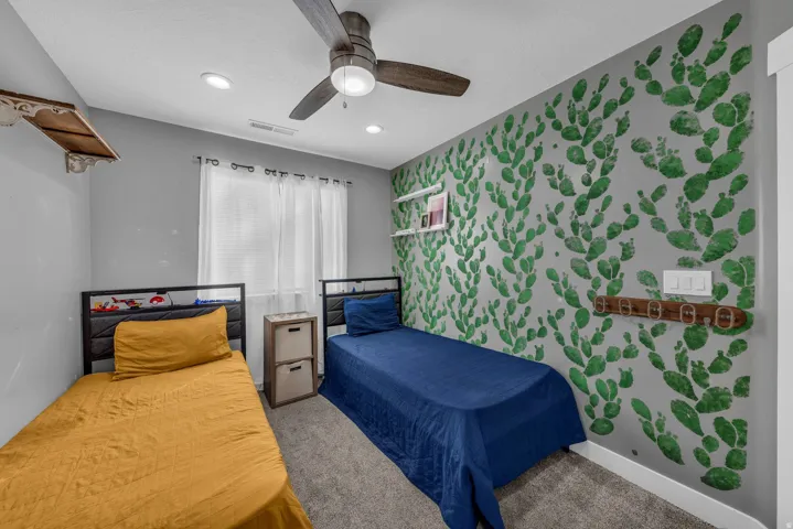 Bedroom with wallpapered walls, an accent wall, carpet, a ceiling fan, and recessed lighting