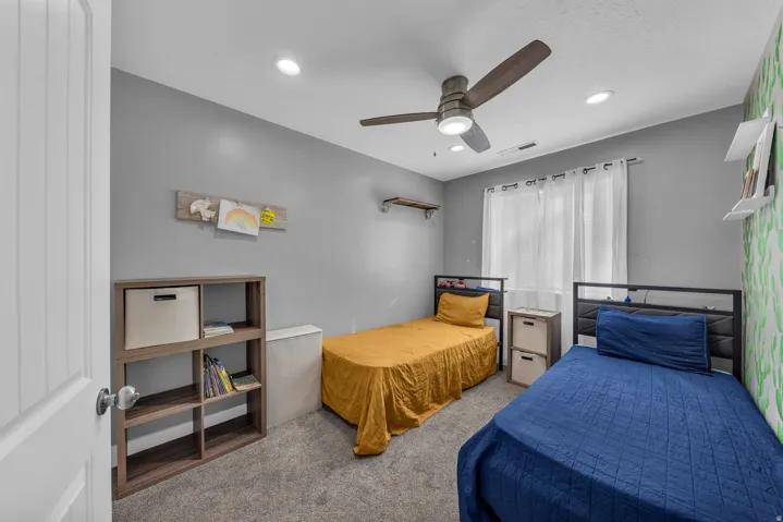 Bedroom with light carpet, ceiling fan, and recessed lighting