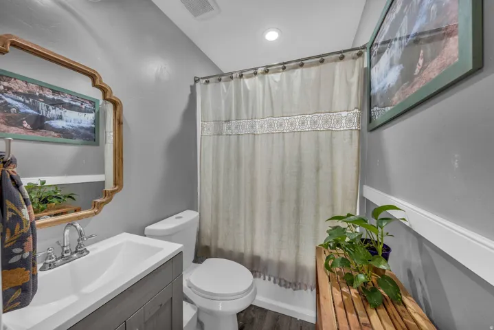 Bathroom with vanity, shower / bathtub combination with curtain, and recessed lighting