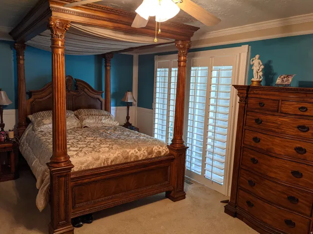 Bedroom featuring carpet flooring, ornamental molding, a ceiling fan, wainscoting, and a textured ceiling
