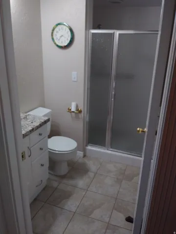 Bathroom featuring vanity, a stall shower, and light tile patterned flooring