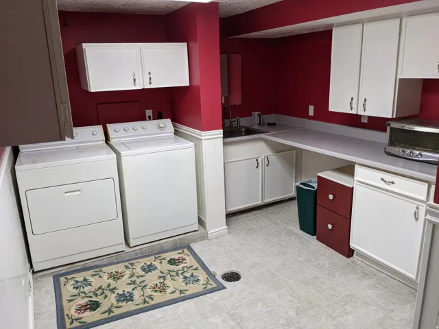 Laundry area featuring cabinet space, separate washer and dryer, and a textured ceiling